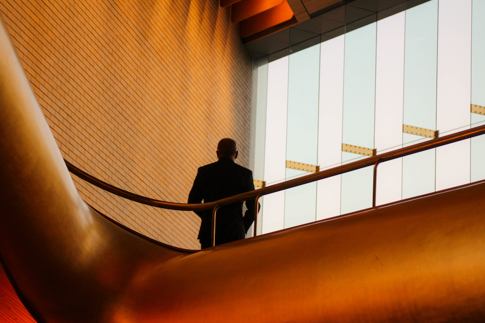 Man standing on inside upper floor of a modern building