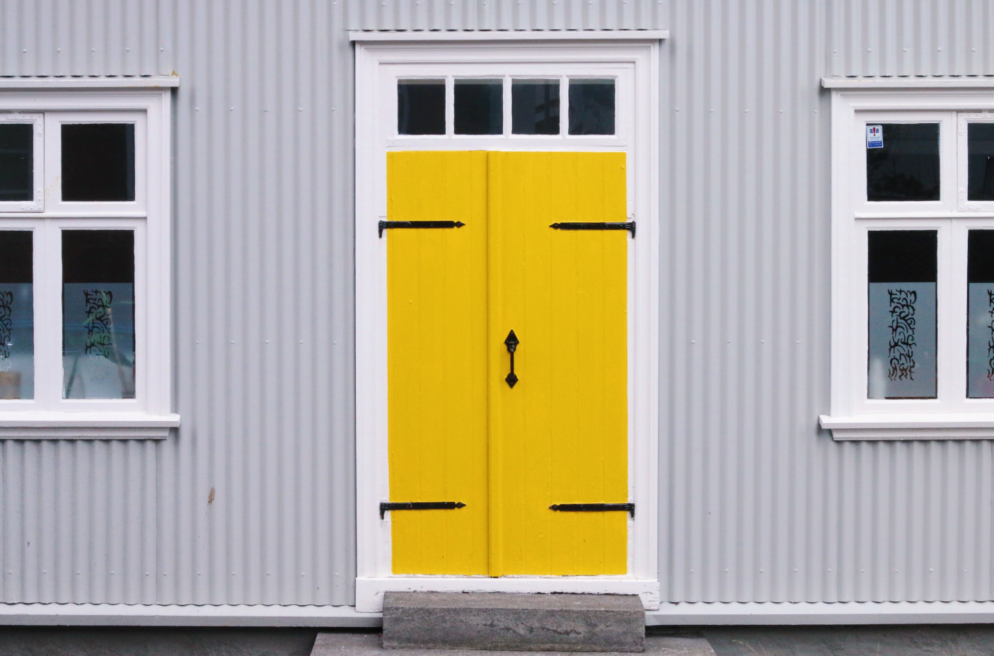 A partial view of a building with a very yellow door.