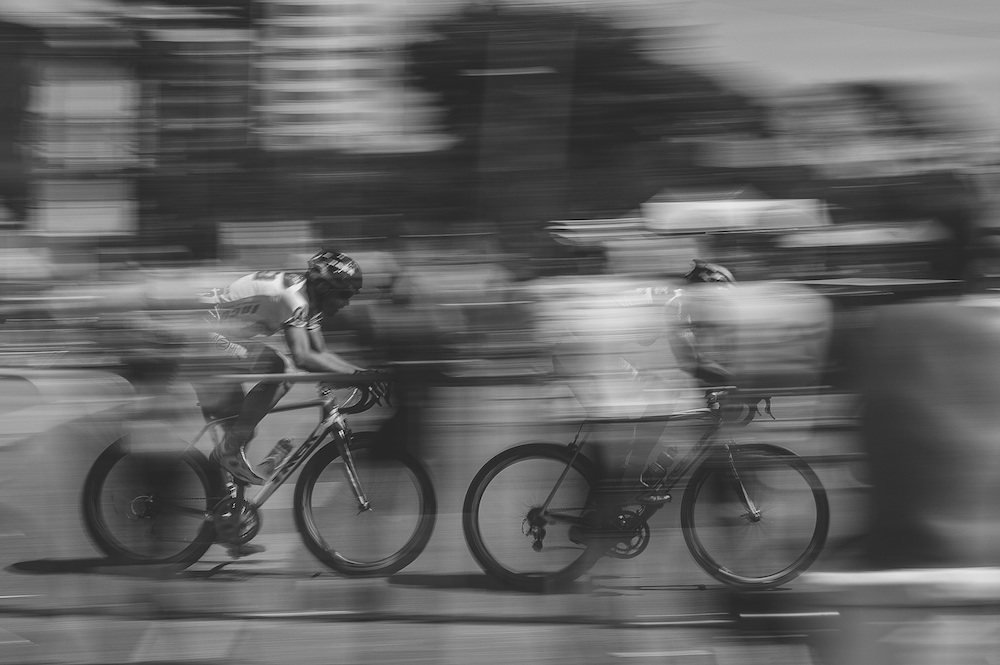 Black and White photo of 2 fast cyclists.